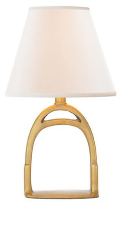 a lamp with a white shade on top of it and a gold frame around the base