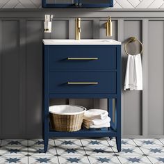 a bathroom vanity with blue drawers and white counter top, gold faucet handles