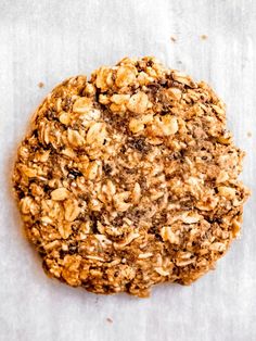 an oatmeal cookie sitting on top of a piece of parchmented paper