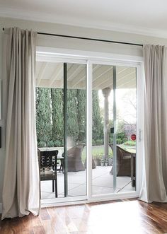 a living room with sliding glass doors and wood floors