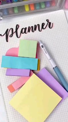 a notepad with sticky notes and a pen on it next to the word planner