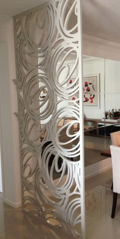 a room divider in the middle of a living room with white chairs and tables