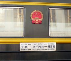 an emblem on the side of a train car that is parked in front of windows