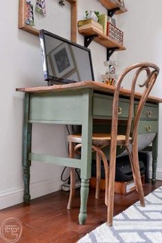 a desk with a laptop on top of it next to a chair and other items