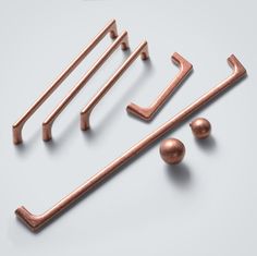 an assortment of copper hardware on a white background with space for the letter e to be inserted