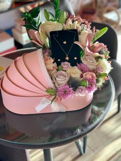 a pink hat with flowers on it sitting on top of a table