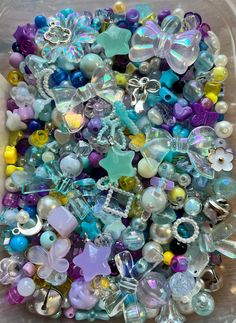 a plastic container filled with lots of different types of beads and charms on top of each other