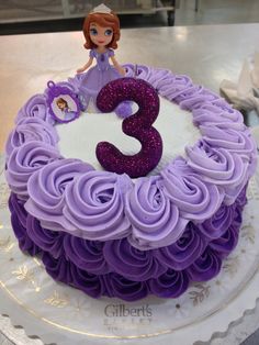 there is a purple cake with the number three on it