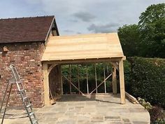 a house being built in the middle of a yard with a ladder on it's side