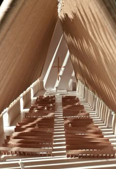 the inside of a church with wooden benches and a cross on it's roof