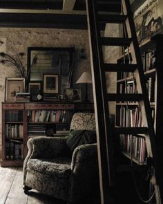 a living room filled with furniture next to a bookshelf full of books and a ladder