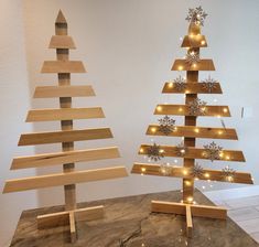 two wooden christmas trees with lights on them