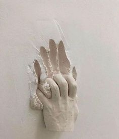 a plaster hand is on the wall and it appears to be holding something in its right hand