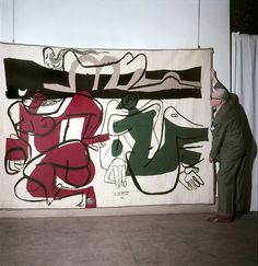 a man standing in front of a large painting