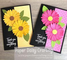 two cards with flowers on them sitting next to each other