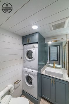 a washer and dryer in a bathroom with wood flooring on the walls