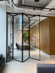 an office with glass partitions in the middle and wood paneling on the walls