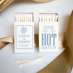 two matchboxes with matches on them next to gold ribbons