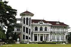 a large white building sitting on top of a lush green field