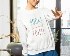 a woman standing in front of a window with her hand up and reading books and coffee written on it