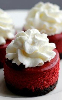 three red velvet desserts with whipped cream on top