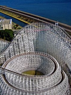 an aerial view of a roller coaster next to the ocean