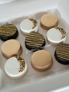 six cookies with gold and white frosting in a box