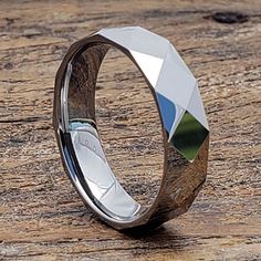 a wedding ring with an unusual design on the outside and inside, sitting on top of a wooden surface