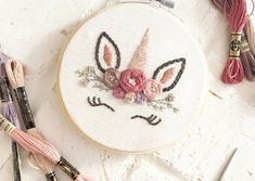 a close up of a embroidery on a table with yarn and scissors next to it