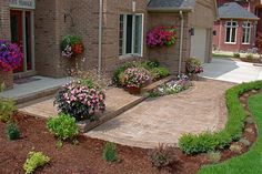 a brick house with flower boxes on the front and landscaping in the back yard area