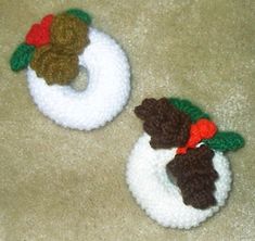 two crocheted snowmen sitting on top of a carpet