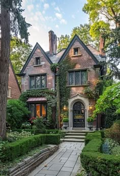 a large brick house surrounded by greenery and trees in front of the entrance to it