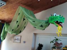 a green paper dragon hanging from the ceiling