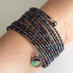 a close up of a person's arm with bracelets and beads on it