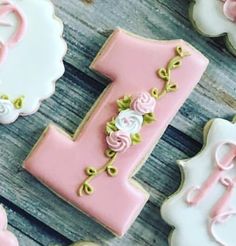 decorated cookies with pink and white icing are arranged in the shape of letter i