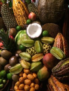 there are many different types of fruits and vegetables on this table, including coconuts