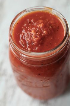 a jar filled with sauce sitting on top of a table