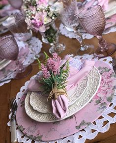 the table is set with pink and white place settings