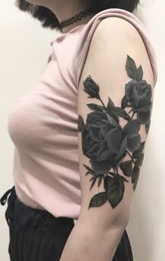 a woman's arm with black roses on the left side of her arm and shoulder