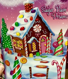 a hand holding up a card with a gingerbread house and candy canes