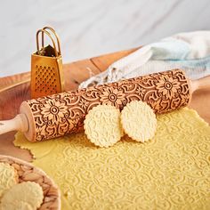 some cookies are laying on a table next to a rolling pin