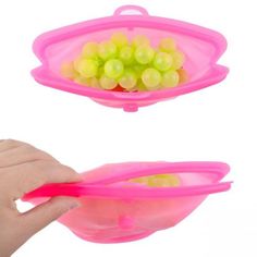 a hand holding a pink plastic bowl with yellow grapes in it and another person's hand reaching for one