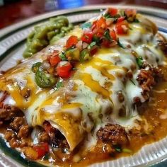 an enchilada on a plate with green beans and peppers