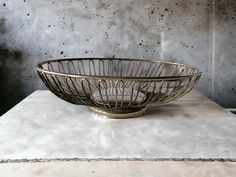 a large metal bowl sitting on top of a white counter next to a gray wall