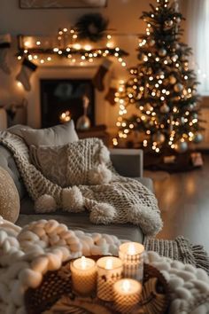 a living room filled with lots of furniture next to a christmas tree and lit candles