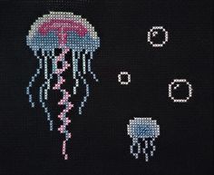 a cross - stitch jellyfish and other sea creatures are depicted in this black background