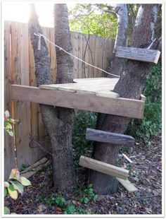 a tree house built into the side of a fence