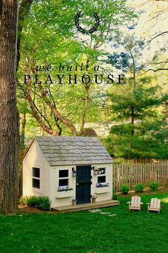 a small white house sitting in the middle of a lush green yard next to a tree