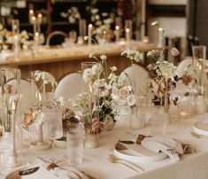 the table is set with white flowers and silverware for an elegant dinnereonal