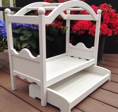 a white wooden step stool with flowers in the background